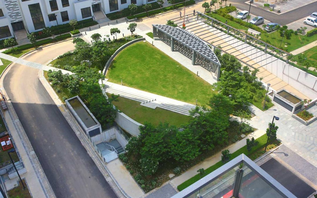 An aerial view of a residential complex incorporating biophilic design features and a green area.