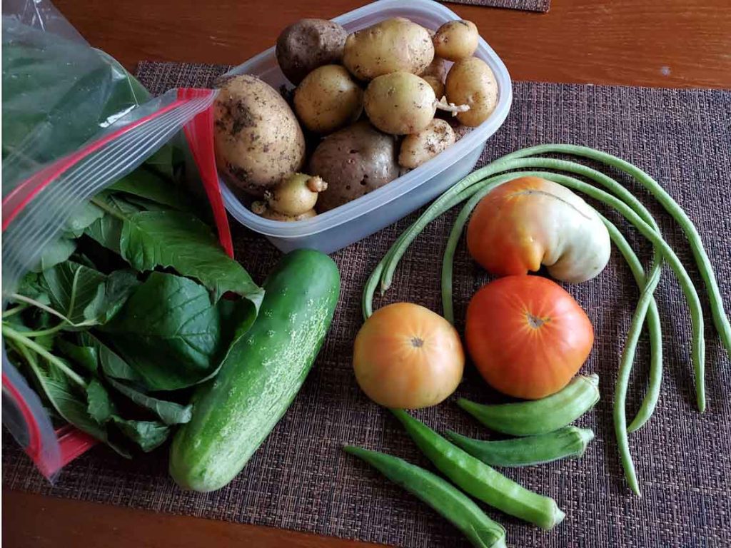 A table topped with lots of vegetables and a basket.